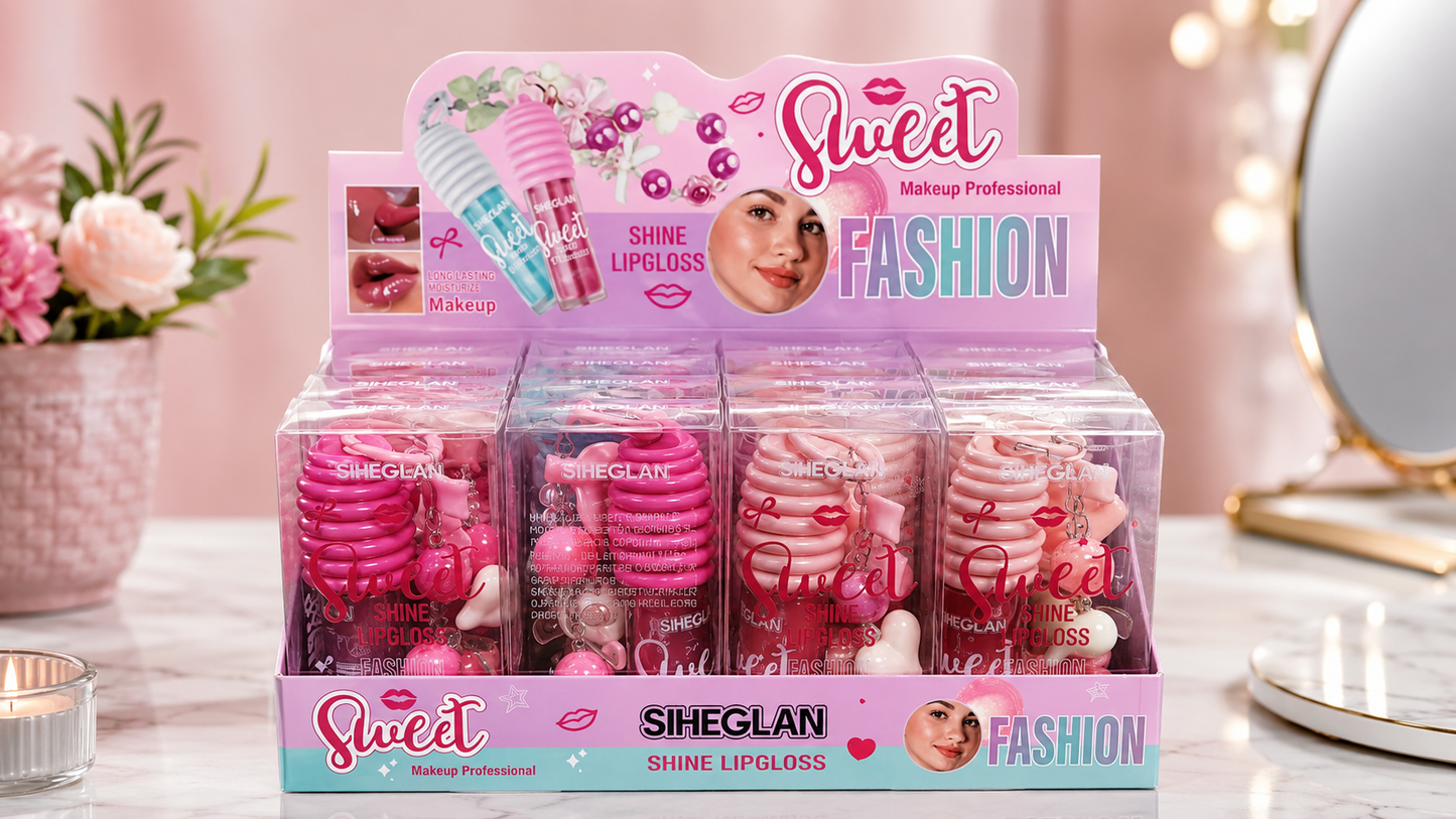 A retail display box of Siheglan Sweet Fashion Shine Lipgloss in various pink shades, set on a marble tabletop with a soft pink background and decorative props.