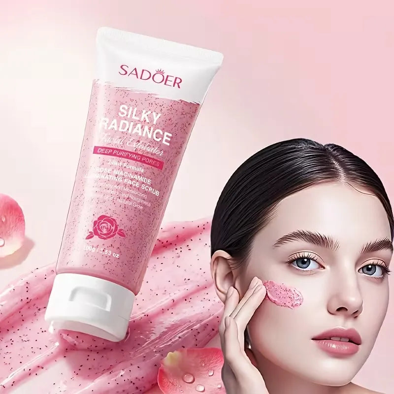 SADOER Silky Radiance Purifying Scrub in a pink squeeze tube, shown next to a model with a clean face and a swipe of the pink scrub on her cheek, set against a soft pink background with rose petals.