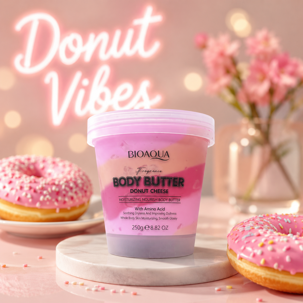 BIOAQUA Body Butter in 'Donut Vibes' scented moisturizer jar, styled with pink frosted donuts on a marble pedestal against a pink bokeh background with 'Donut Vibes' text.