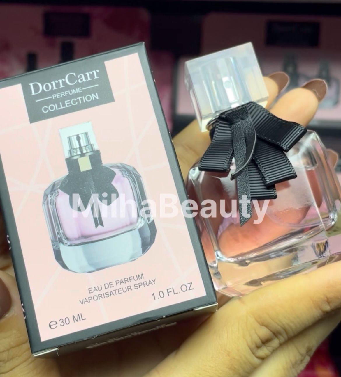 Perfume bottle with black bow and packaging labeled 'DorrCarr' held by a hand.