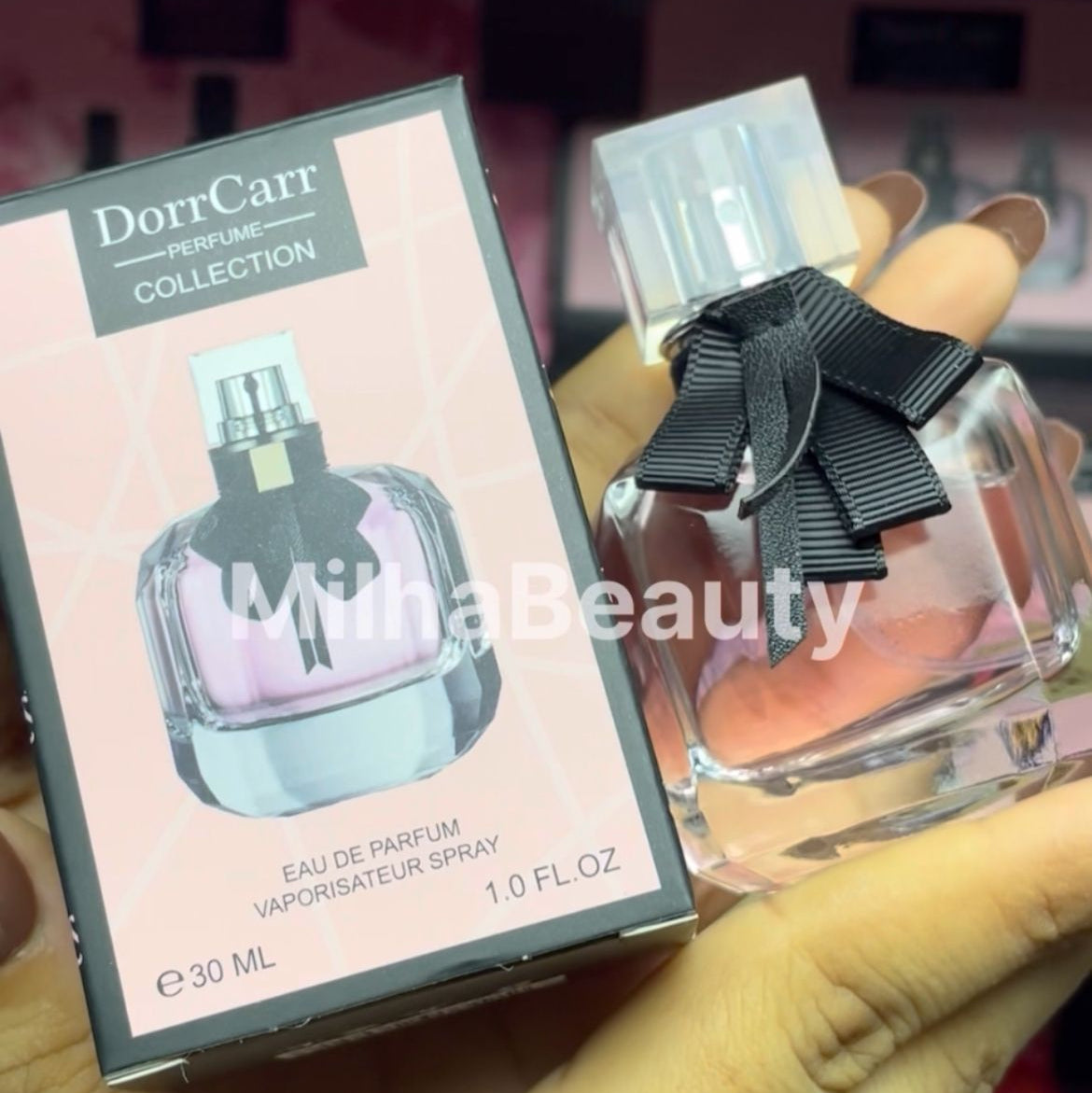 Perfume bottle with black bow and packaging labeled 'DorrCarr' held by a hand.
