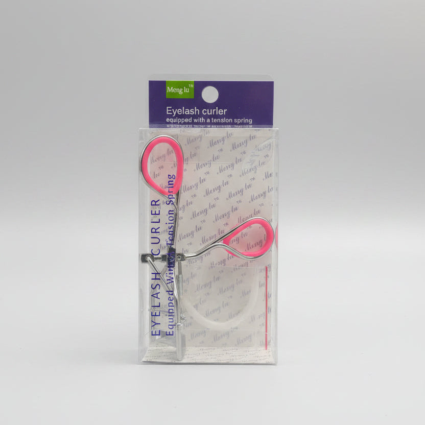 A packaged eyelash curler set with pink-handled tools and a clear plastic sleeve, placed on top of a black laptop keyboard.