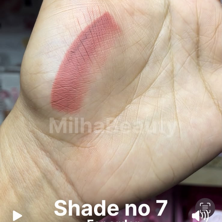 A close-up of a hand showing a swatch of lipstick shade no. 7 in a dusty rose pink color, with text overlays indicating the price and brand MilhaBeauty.