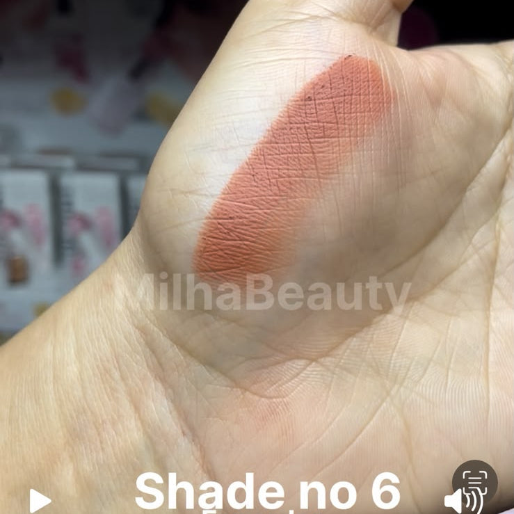 A close-up of a hand showing a swatch of a peachy pink cosmetic cream on the back of the hand, with text overlays reading 'Shade no 6 For order', 'www.milhaabeauty.