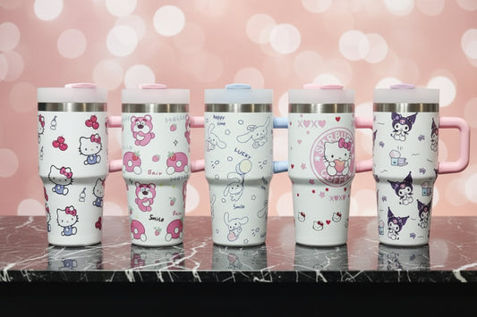 Five Hello Kitty themed travel tumblers with different character designs, displayed side-by-side on a dark marble surface against a pink bokeh background.