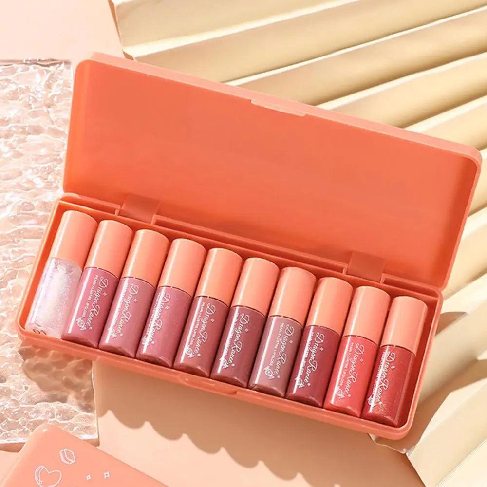 Set of lip glosses in an open orange case on a light background