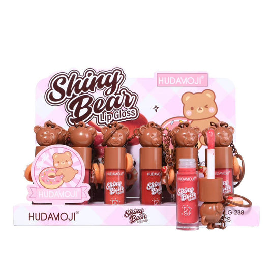 Hudamoji Shiny Bear Lip gloss display set featuring multiple lip gloss tubes with bear-shaped caps, a pink bear illustration card, and a small bear-shaped keychain, all arranged on a branded pink display stand.