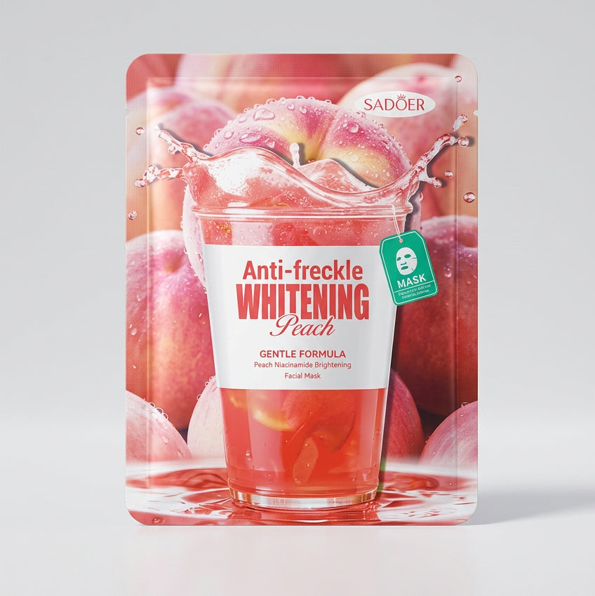 A Sadoen Anti-freckle Whitening Peach sheet mask packet lying on a beige patterned fabric surface. The packet features a graphic of a glass of pinkish peach juice surrounded by peaches, with the product name printed in red and white text.