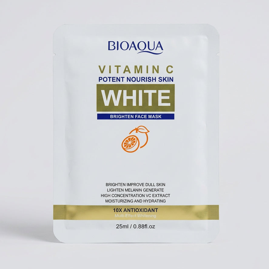 Bioaqua Vitamin C White Brighten Face Mask sachet, photographed on a dark surface with a keyboard and other items in the background.