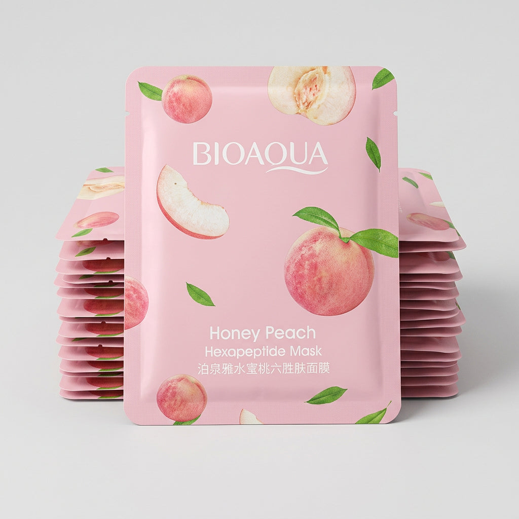A pink BIOAQUA Honey Peach Haspateptide Mask packet placed on top of other skincare packets on a dark keyboard and fabric surface.