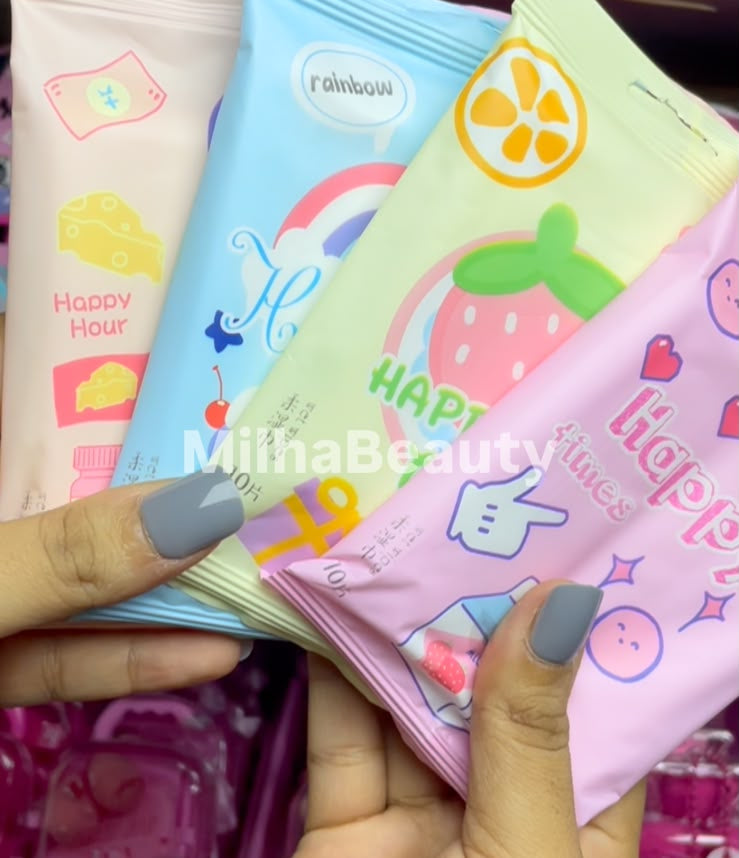 Three colorful packaged snack pouches held in a person's hand, with a pink pouch in front featuring a strawberry illustration and the words 'Happy Strawberry.' The background shows a retail shelf with more packaged items.