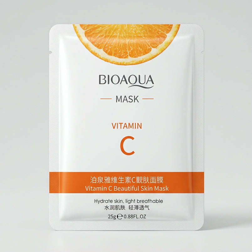 A single BIOAQUA Vitamin C mask packet lies on a dark keyboard. The packet is white with orange accents, featuring a citrus slice graphic at the top and Chinese text below the English product name.