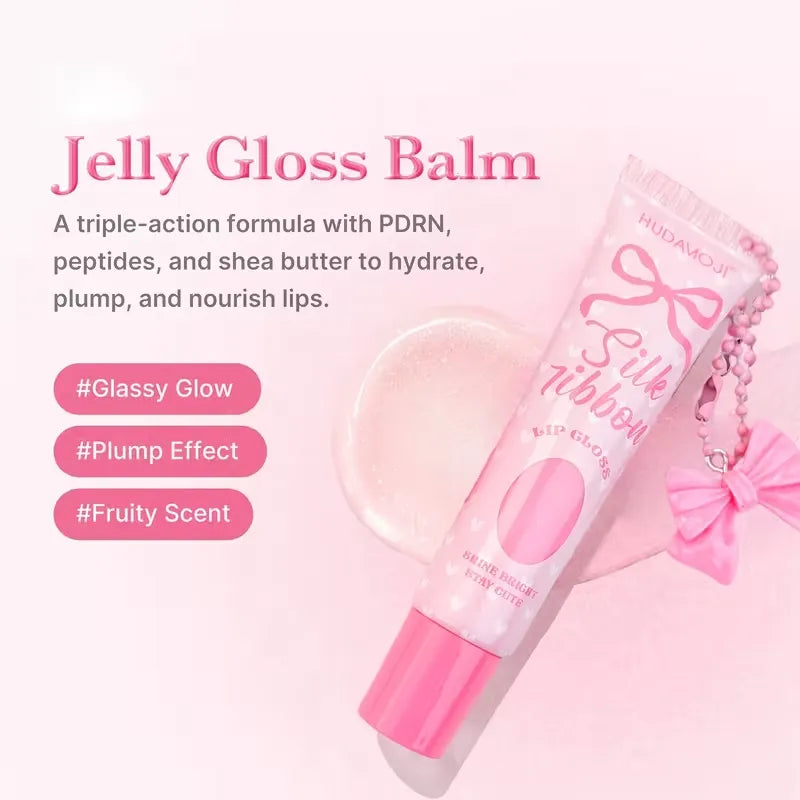 Pink tube of HudaKouji Jelly Gloss Balm with a pink cap, shown on a soft pink background with descriptive text and a small gloss swatch.