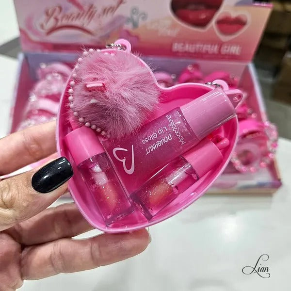 Pink lip gloss set with heart-shaped case held by a hand, with 'Beautiful Girl' packaging in the background.