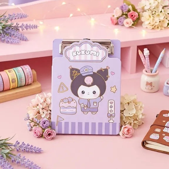 A pastel purple cartoon clipboard with a character illustration, styled on a pink desk with flowers, pastel washi tape, and stationery accessories.