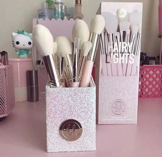 Makeup brushes in a sparkly holder with a 'BH' logo, next to a box labeled 'Hairy Lights'.
