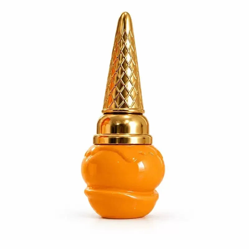 An orange and gold novelty perfume bottle shaped like a stylized face, featuring a textured gold cap resembling a diamond-patterned cone, set against a plain white background.