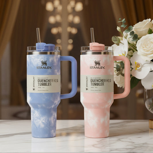 Two Stanley Quencher H2O tumblers, one blue and one pink, on a surface
