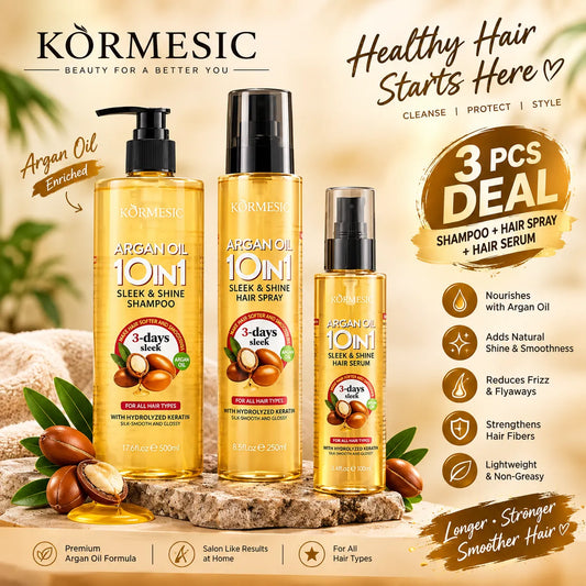 Three Körmesic hair care products displayed together on a styled stone surface with argan nuts and green leaves. The set includes an enriched Argan Oil 10%1 Sleek & Shine Shampoo, a larger Argan Oil 10%1 Sleek & Shine Shampoo bottle, and an Argan Oil 10%1 Sleek & Shine Hair Serum.