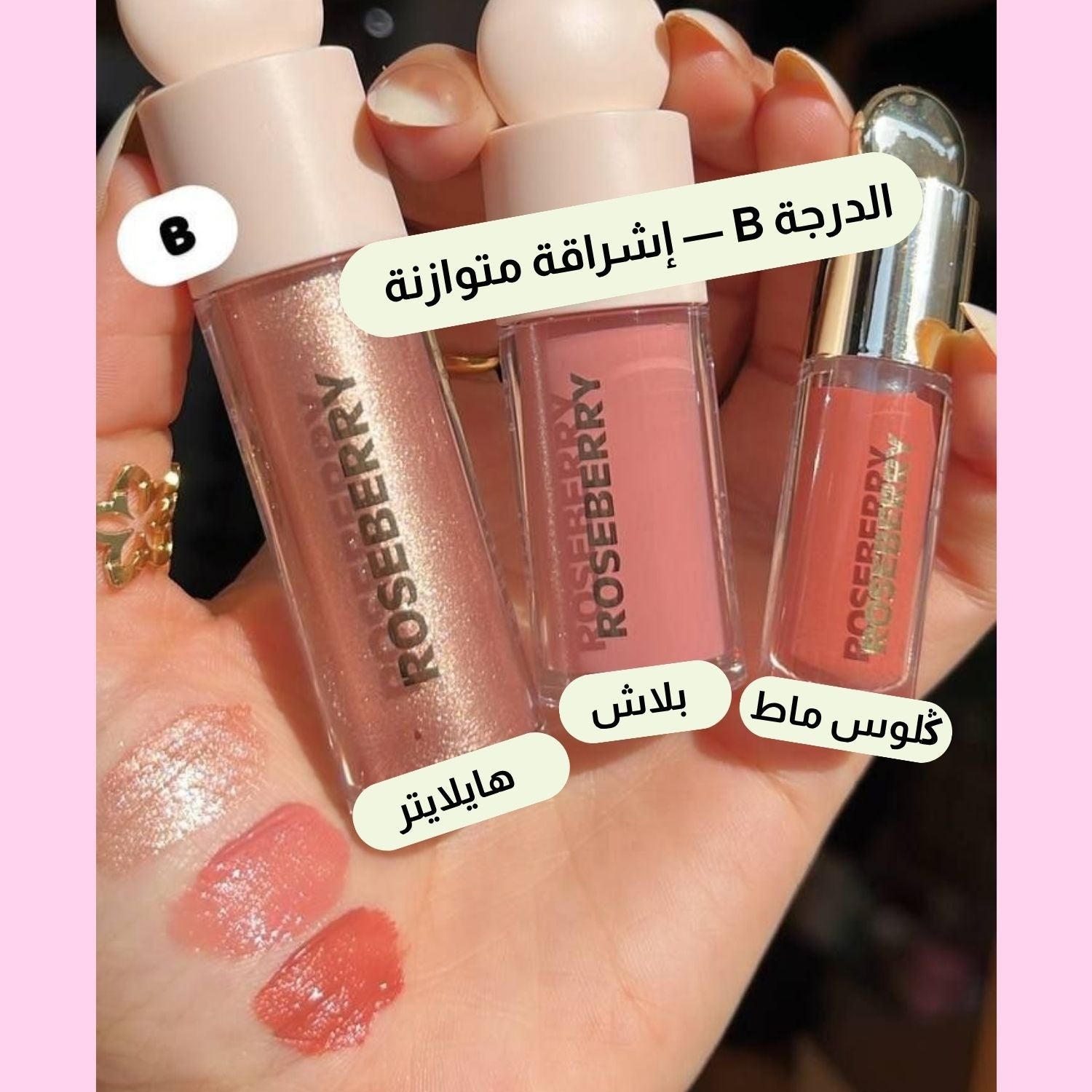 Three Roseberry lip gloss tubes held in a hand, with three corresponding swatches on the palm. Arabic text labels each shade, and the background is pink with a light pink border.