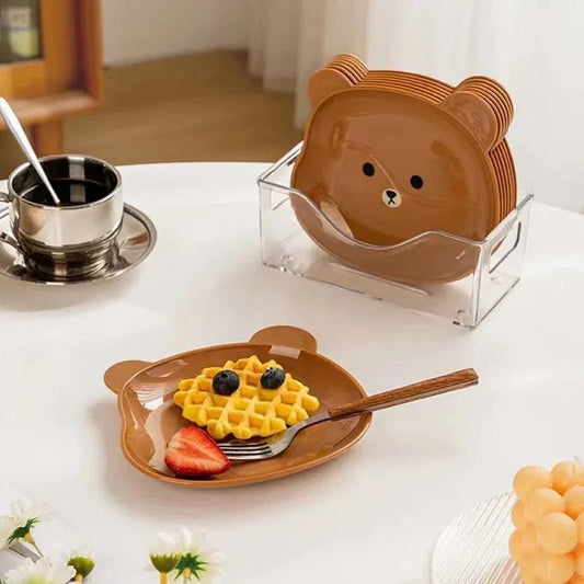 Set of bear-shaped plates on a table with a cup of coffee and waffles.