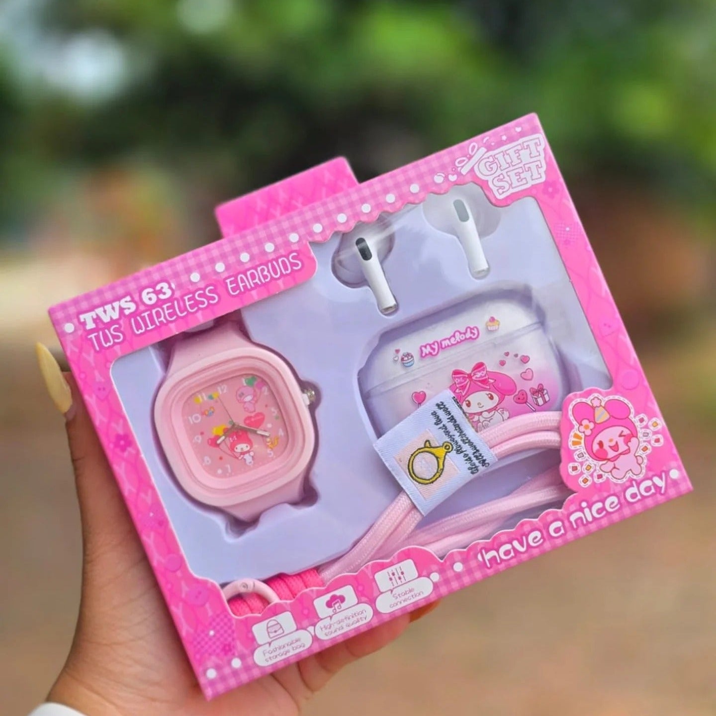A pink My Melody gift set held in a hand, containing a pink watch, white earbuds, and a small accessory card, in its original retail packaging with a pink My Melody design.