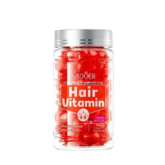 A clear plastic bottle of SADOER Hair Vitamin capsules filled with red capsules, featuring a silver cap and a red and white label, on a white background.