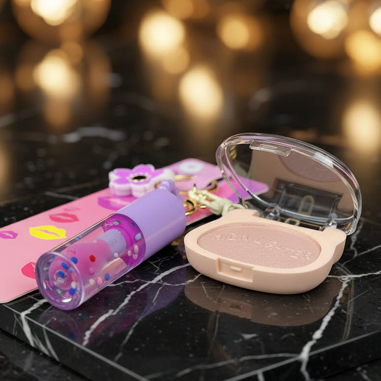 A cosmetic keychain set featuring a lavender lip gloss tube, a clear compact with a pink highlighter labeled 'HIGH LIGHTERS,' and a pink flower keychain charm on a black textured background.