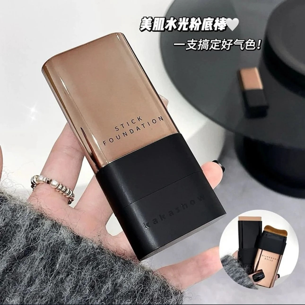 Hand holding a stick foundation with brand name, close-up view.