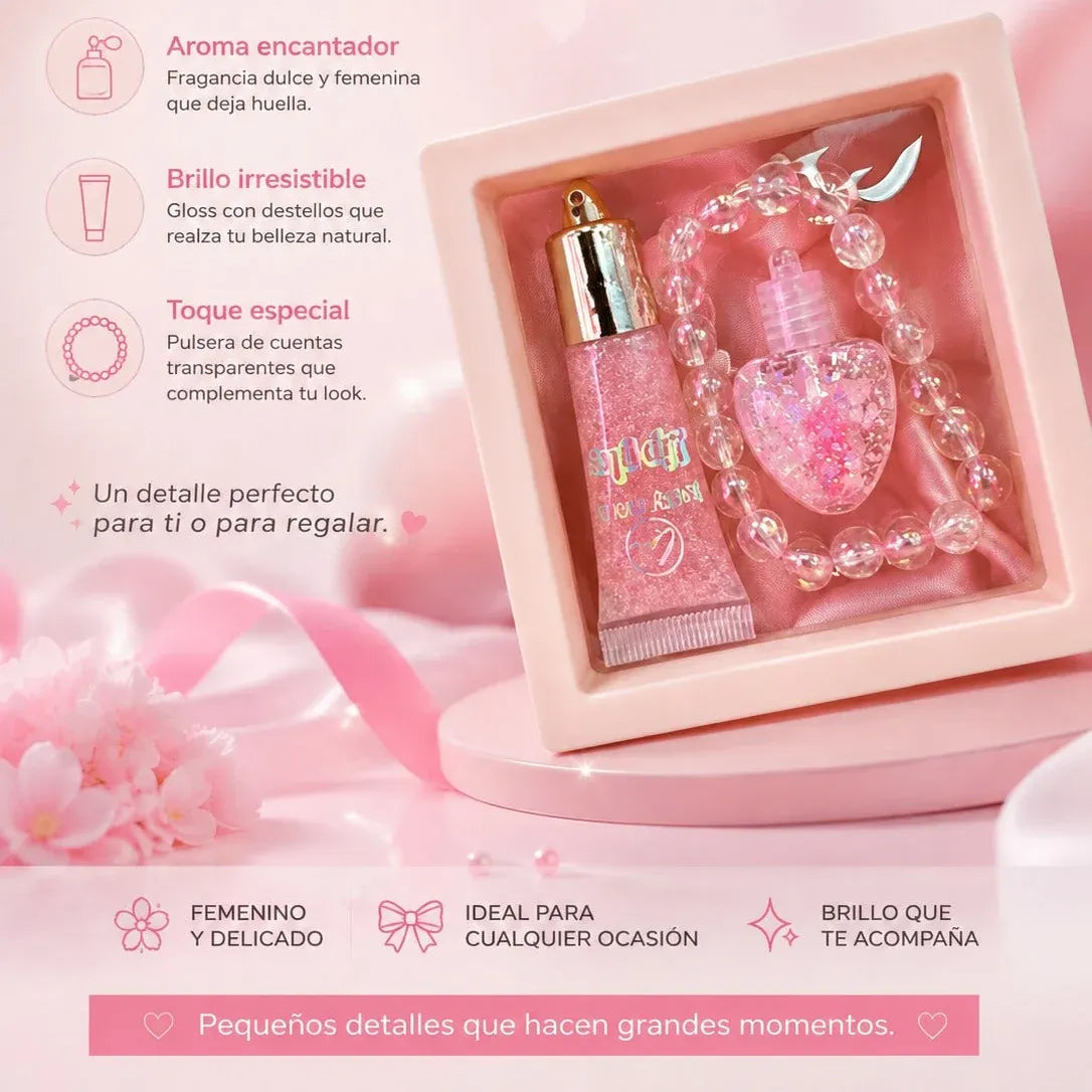 Pink gift set in an open square box with a glittery pink tube, a heart-shaped pink bottle, and a beaded bracelet, shown on a pink background with Spanish promotional text.