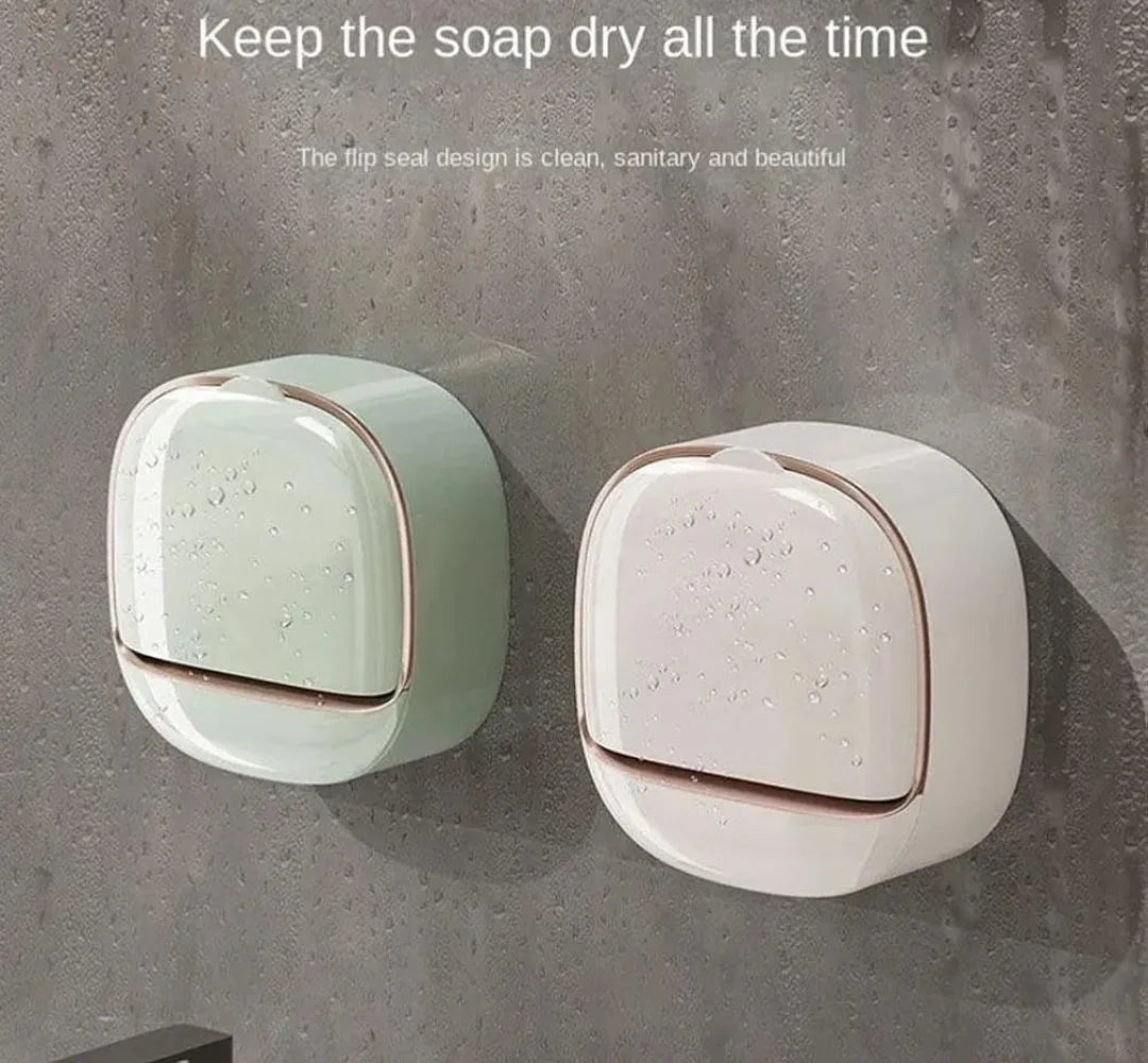 Two wall-mounted soap dryers in mint green and off-white with metallic rose gold trim, shown on a textured gray wall with water droplets. Text at the top reads 'Keep the soap dry all the time'.