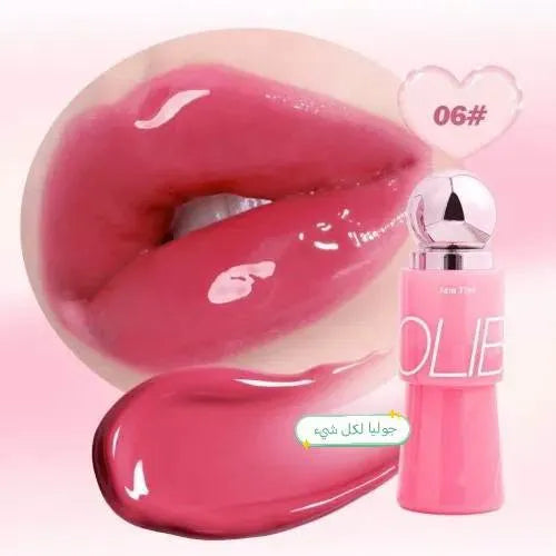 A pink lip gloss bottle labeled OLIE with a silver cap, shown beside a large close-up of glossy pink lips and a smear of the gloss on a pale pink background. A heart-shaped label reads 06# and Arabic text appears near the gloss smear.