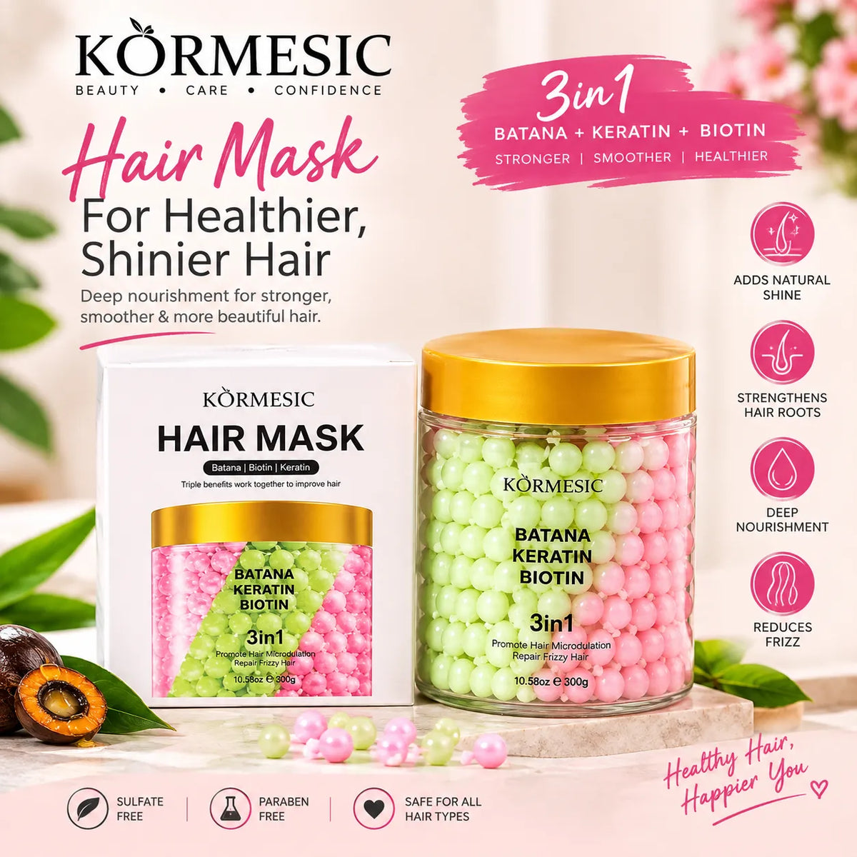 Körmesic 3-in-1 Batana Keratin Biotin Hair Mask shown with its white and pink packaging box and a clear jar filled with pink and green round hair mask beads, set against a soft pink background with decorative leaves and fruit.